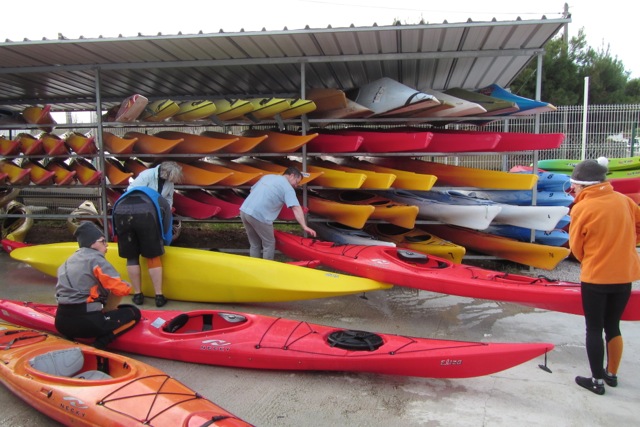 Most of the kayaks are stored outside under a shed roof. Each kayak is numbered and is stored in a spot with that number on the rack.